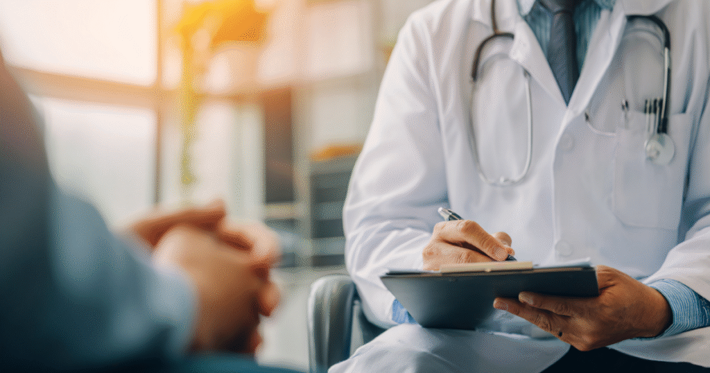 Doctor consulting with patient and writing medical notes — representing professional supervision for peptide and metabolic treatments.